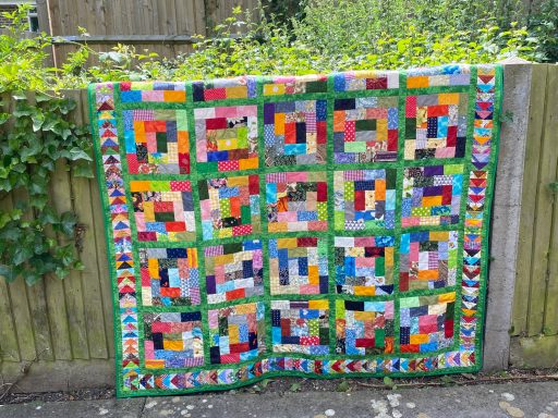 Scrappy quilt with flying gees pattern around the border